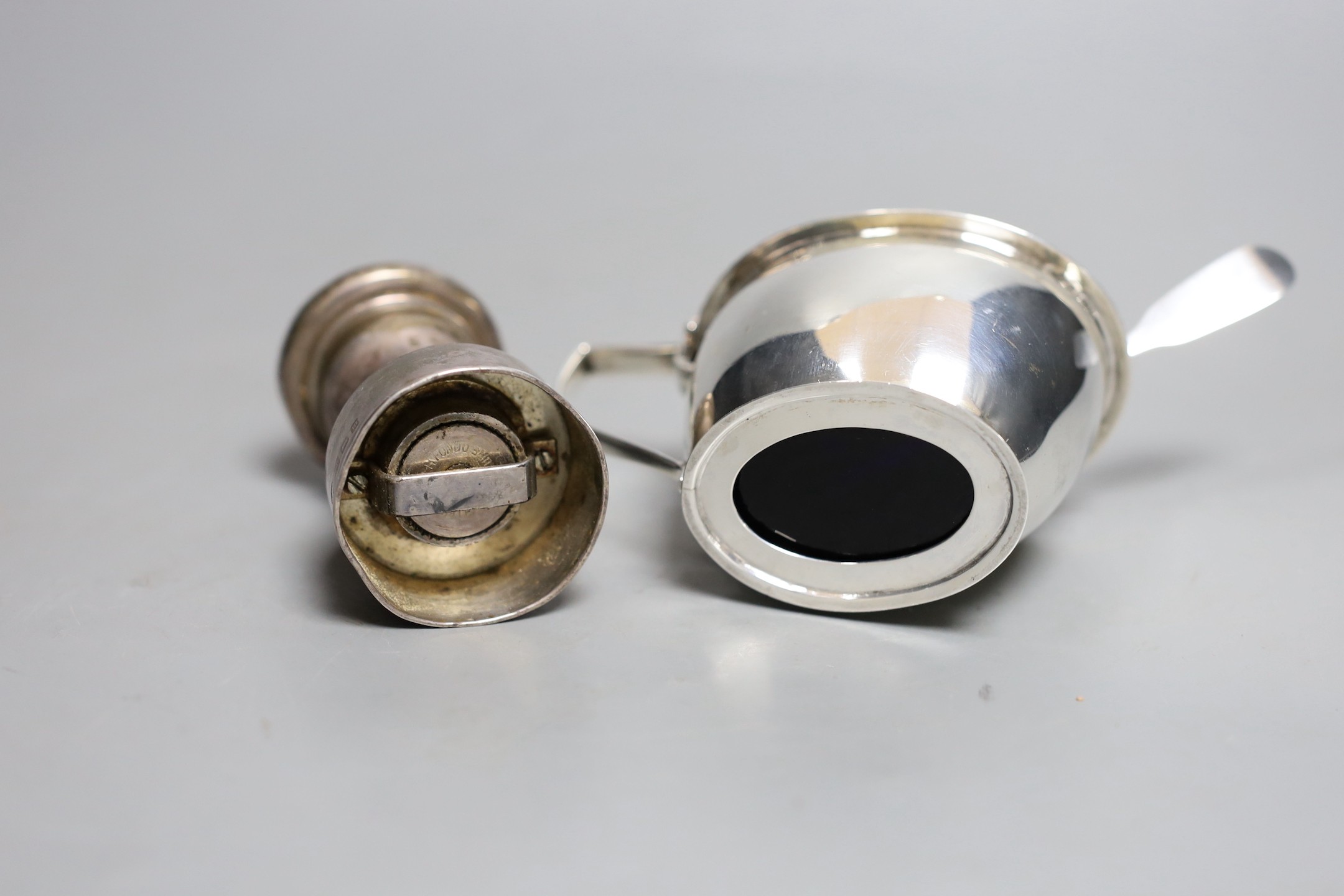 A George V silver mounted pepper mill, Birmingham, 1911, 80mm and a similar silver mustard pot.